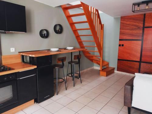 a kitchen with a counter and a spiral staircase at Nuitées / télétravail in Dunkerque