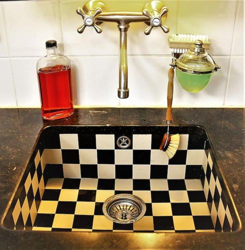 a bathroom sink with a checkerboardkered counter top at Onthaast & Geniet in Den Helder