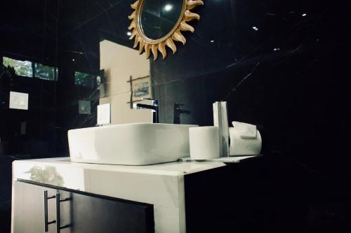 uma casa de banho com um lavatório e um espelho em Jungle Home with King Beds -5 Minutes from the Beach em Uvita