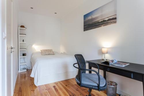 een slaapkamer met een bed en een bureau met een stoel bij Apartment Príncipe Real Area in Lissabon