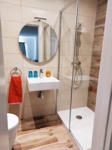 y baño con ducha, lavabo y espejo. en 2 Bedroom Apartment in San Gwann, en San Ġwann