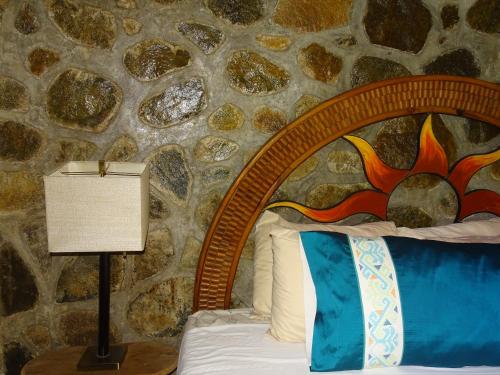 a bed in a room with a stone wall at Villas Vista Suites Sayulita in Sayulita