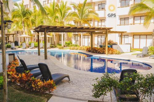 a pool at a hotel with chairs and palm trees at Con alberca a 5 minutos de la playa by G P S rentas in Mazatlán