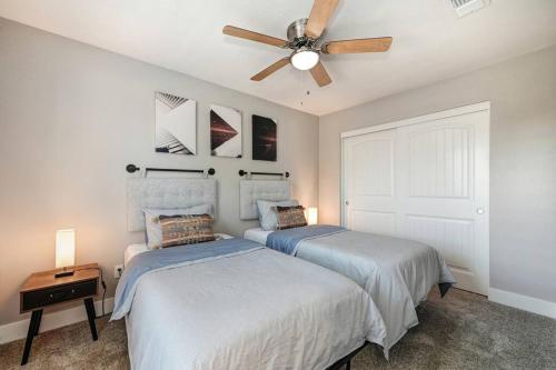 two beds in a bedroom with a ceiling fan at Sacramento Two-Story Condo Near Oak Park Brewing! in Sacramento