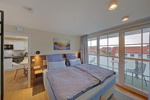 a bedroom with a bed and a view of a kitchen at Endlich Theda in Juist