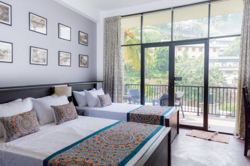 a bedroom with two beds and a large window at Kandy City View in Kandy