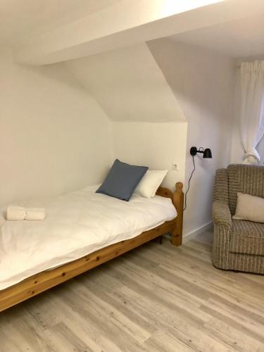 1 dormitorio con 1 cama y 1 silla en Gasthaus am Schloss en Karlsburg