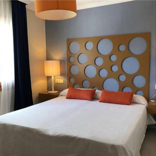 ベラにあるVerano Azulのベッドルーム1室(白い大型ベッド1台、赤い枕2つ付)