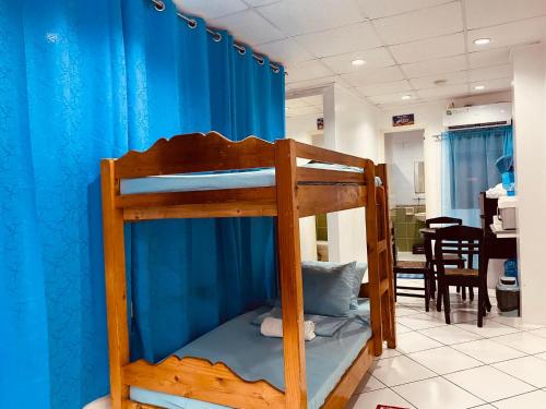 a bunk bed in a room with a blue curtain at ROMY'S PLACE - ENTIRE 2ND FLOOR APARTMENT in Vigan