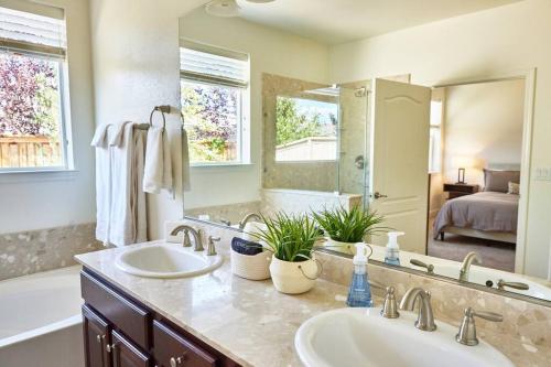 een badkamer met 2 wastafels en een grote spiegel bij NEW Upscale House, Tahoe 30-min w/ Cal King in Steamboat