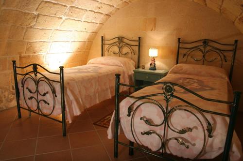 a bedroom with two beds in a room at La Tana del Lupo in Oria