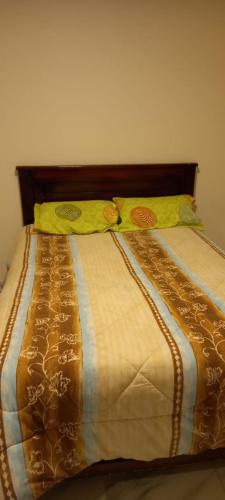 Una cama con dos almohadas encima. en Hostal NOA El Valle, en Quito