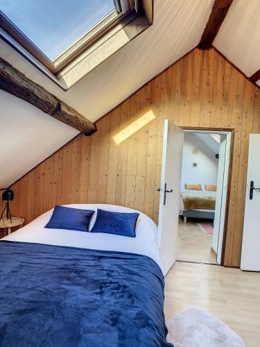 a bedroom with a large bed with blue pillows at Charmant triplex centre-ville de Chantilly in Chantilly