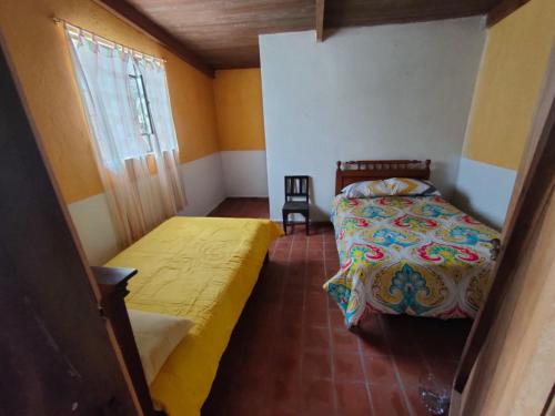1 dormitorio con 2 camas y ventana en Pululahua Magia y Encanto en Quito