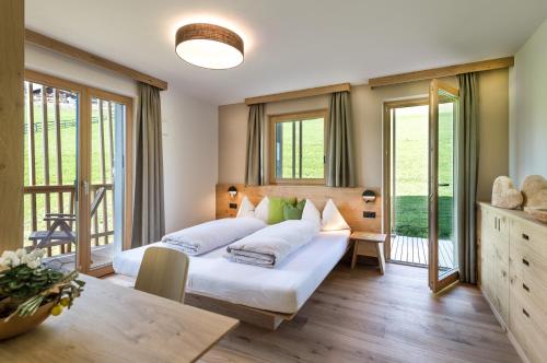een slaapkamer met een bed en een groot raam bij Hoferhof in Maranza
