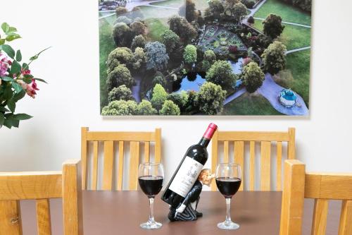 a bottle of wine sitting on a table with two glasses at Shrewsbury Cottage in Shrewsbury