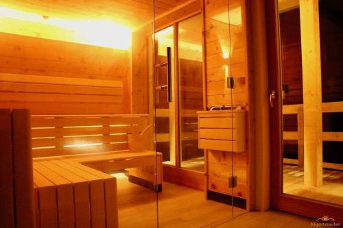 a sauna with a bench and a glass shower at Almchalet Klippitzzauber in Bad Sankt Leonhard im Lavanttal