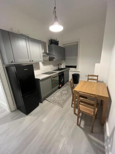 a kitchen with a table and a black refrigerator at studio flat in Camden Town in London
