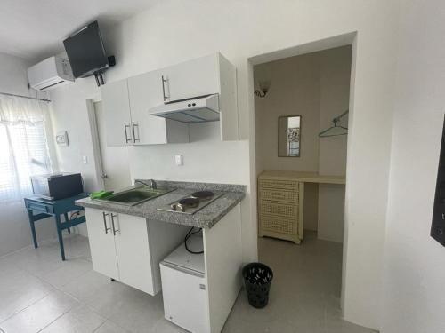 Loft 208 في أكابولكو: مطبخ مع دواليب بيضاء ومغسلة ومكتب