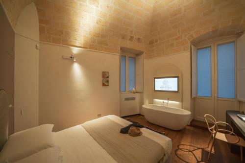 a bedroom with a tub and a bed and a bath room at Palazzo Fontana B&B e SPA in Gravina in Puglia