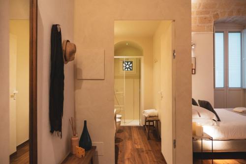 a room with a bedroom and a bed and a mirror at Palazzo Fontana B&B e SPA in Gravina in Puglia