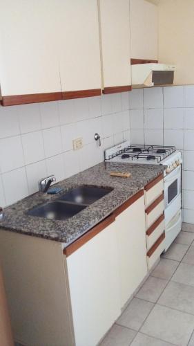 a kitchen with a sink and a stove at Dalmi in San Nicolás de los Arroyos