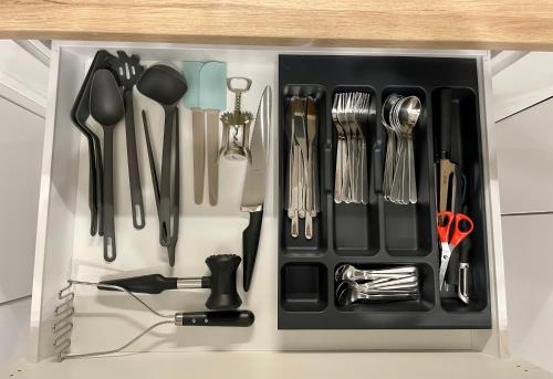 a drawer filled with utensils on top of a counter at Apartments Sleep & GO Modlin Airport in Nowy Dwór Mazowiecki