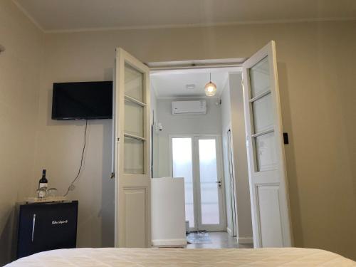 a bedroom with a door open to a room with a television at Gomez Point Mendoza in Mendoza