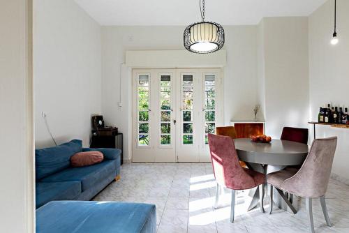 - un salon avec un canapé bleu, une table et des chaises dans l'établissement Rechavia Apartment, à Jérusalem
