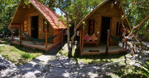 a small wooden house with a hammock in front of it at Eco Glamping Caraiva in Caraíva