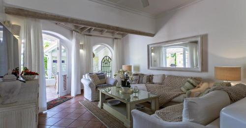 a living room with a couch and a table at Sugar Hill, Coconut Shell by Barbados Sothebys International Realty in Saint James