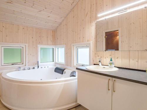a bathroom with a large tub and a sink at Holiday home Tranekær XXXIII in Tranekær