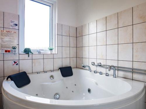 a white bath tub in a bathroom with a window at Luxury Spa Retreat by Sea in Humble