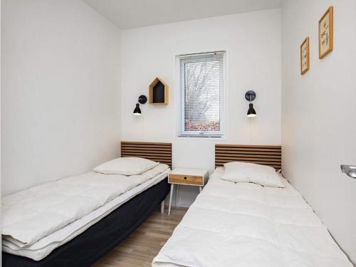 two beds in a room with white walls and a window at Luxury Spa Retreat by Sea in Humble