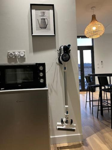 un appareil photo sur un tripod dans une cuisine avec un four micro-ondes dans l'établissement Maison Origine Périgueux, à Périgueux