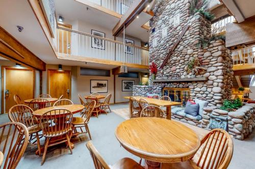 a restaurant with tables and chairs and a stone wall at Aspen Mountain Lodge in Aspen