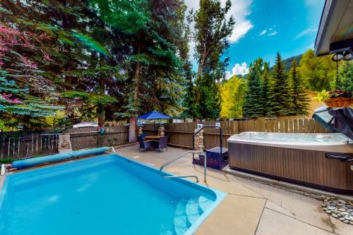 a swimming pool in a backyard with a hot tub at Aspen Mountain Lodge in Aspen