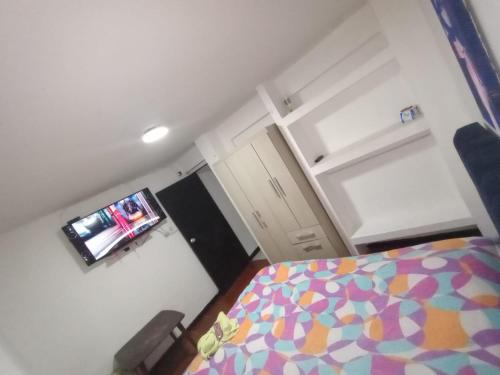 um pequeno quarto com uma cama e uma televisão em Cerca al club militar embajada americana, Corferias 502 em Bogotá