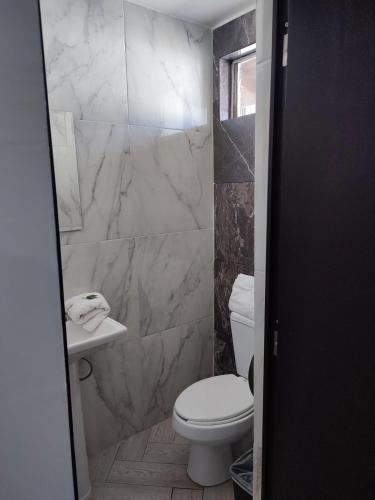 a bathroom with a toilet and a sink at Hotel Don Quijote in Mexicali