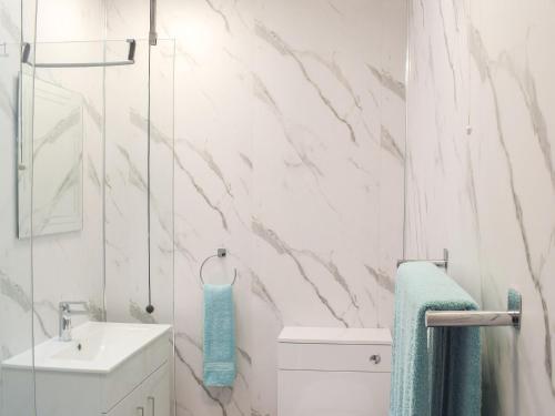 a white bathroom with a sink and a shower at Fiddlers Rest in Ballantrae