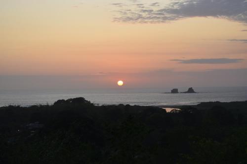 a sunset over the ocean with the sun in the sky at Bungalows Ayampe in Ayampe