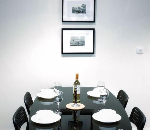 una mesa negra con copas y una botella de vino en Two Bedroom Luxury Apt with film style, en Swansea