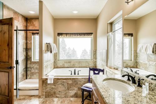 La salle de bains est pourvue de 2 lavabos, d'une baignoire et d'une fenêtre. dans l'établissement Vista Linda Cabin, à Angel Fire