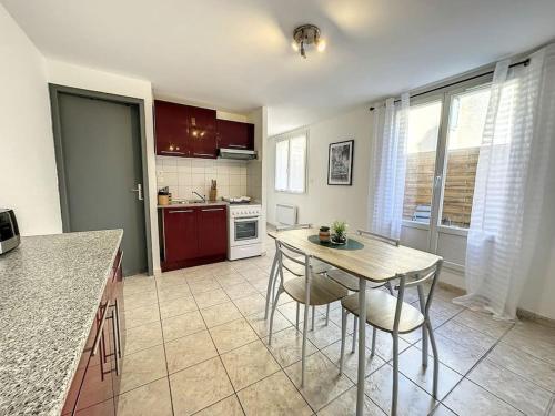 une cuisine avec une table et des chaises dans une cuisine dans l'établissement Spacieux T2 tout confort, à Tarbes