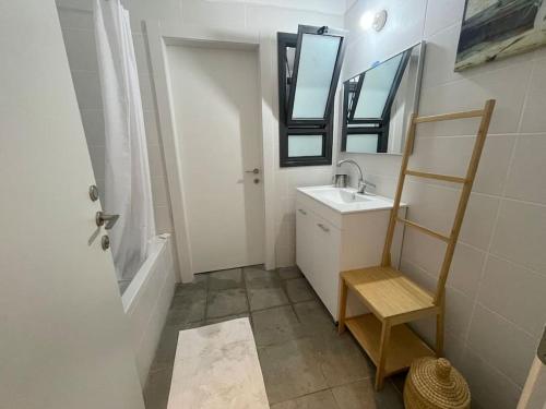een badkamer met een wastafel en een spiegel bij Garden North With built in BBQ in Qiryat Shemona