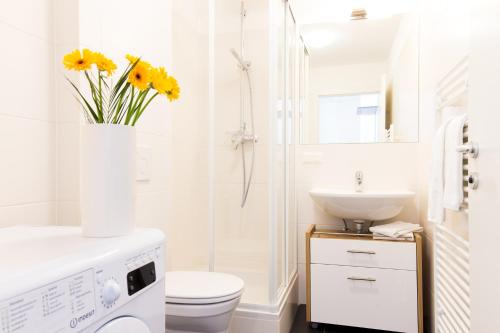 Baño blanco con aseo y lavamanos en Rafael Kaiser - Aurea Apartment - Contactless 24h Check-In -, en Viena