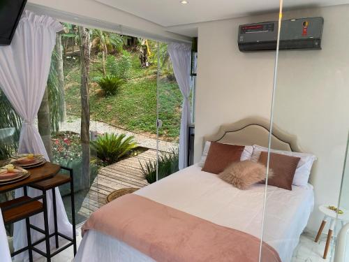 1 dormitorio con cama colgante y patio en Loft Vidro Vitoriano em Condomínio Rota do Vinho São Roque, en Mairinque