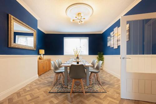 a dining room with blue walls and a table and chairs at The Stanley Spacious Modern Home Near the Beach perfect for a family holiday or Contractor stay in Blythe