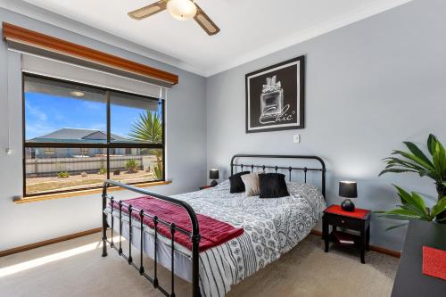 a bedroom with a bed and a large window at Fancy Moonta Bay in Port Moonta