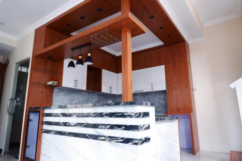 a kitchen with wooden cabinets and a counter top at Blue Villa in Balikpapan